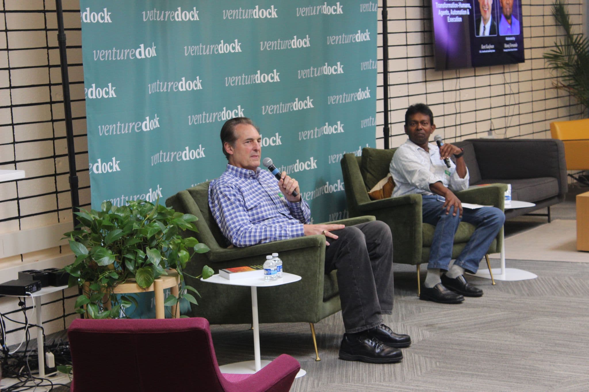 Manoj Fernando in a fireside conversation on stage in front of a VentureDock backdrop.